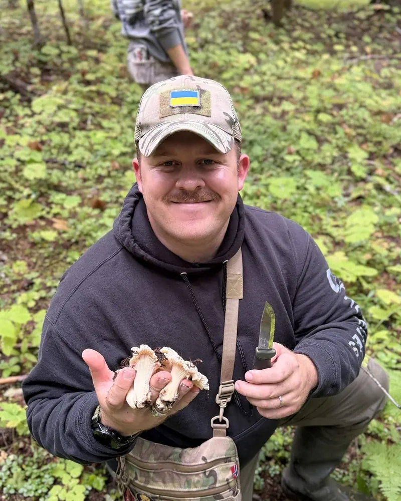 Adriel foraging in a field with a knife and a basket