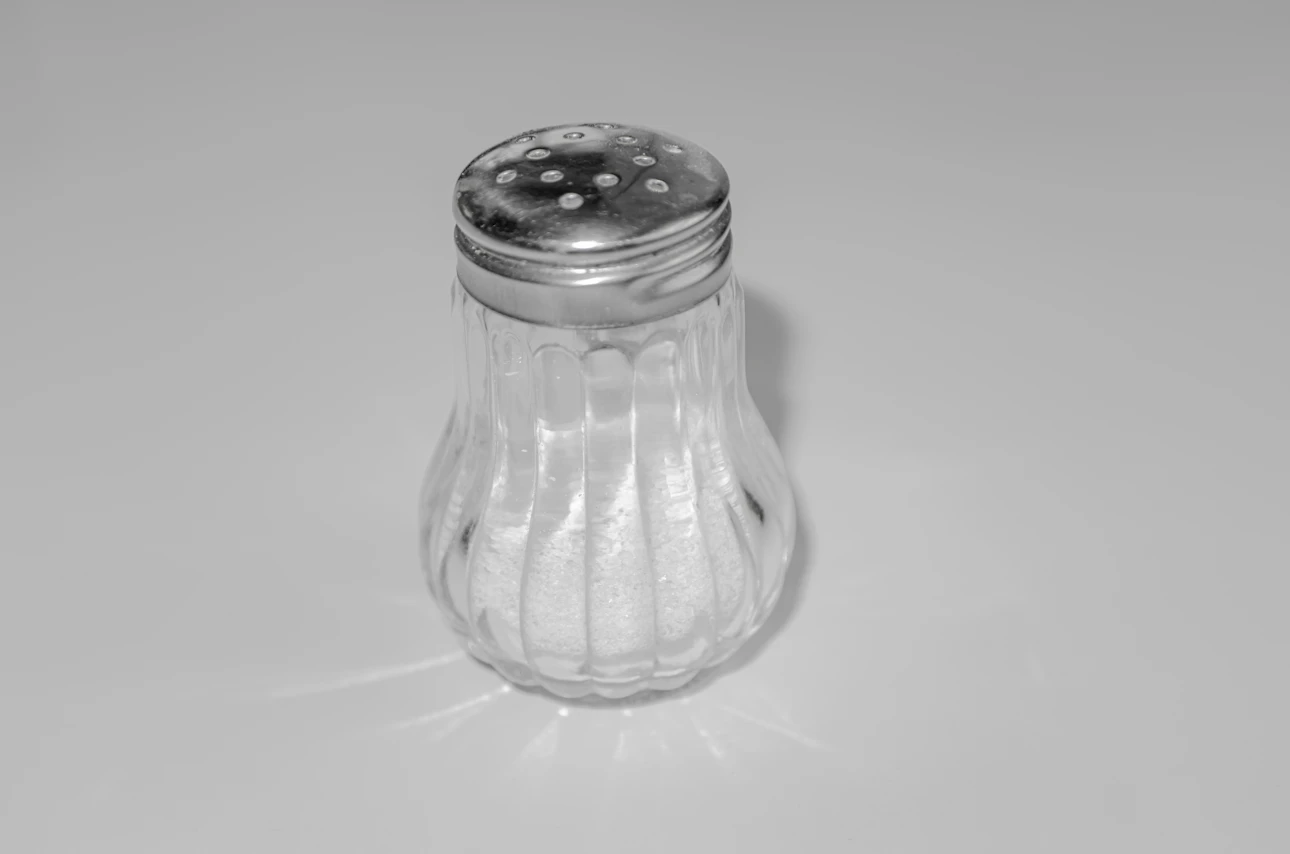 A salt shaker on a table, showing how salt shelf life depends on storage
