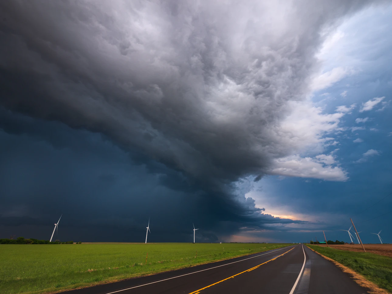 Dark storm clouds rolling in over an open road, the kind of approaching coastal storm that knocks out power for days