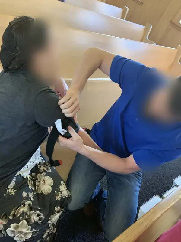 A windlass tourniquet being applied high on the upper arm during a hands-on bleeding-control class